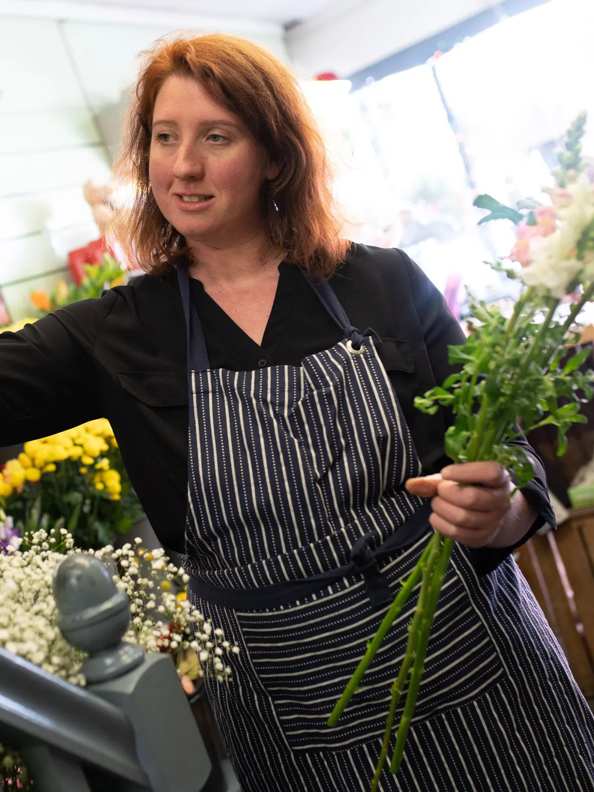 Blomsterdekoratør med blomster i butikken